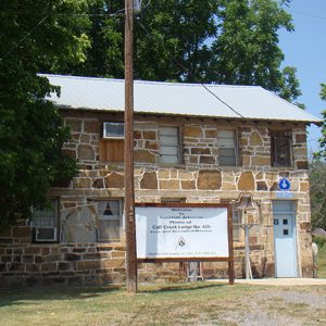 Two-story stone building with sign