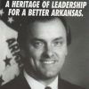 White man smiling in suit and tie with flag behind him with text and logo on campaign brochure