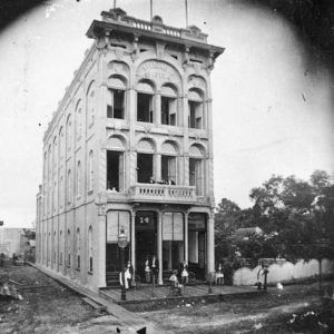 Narrow three-story building on dirt street corner