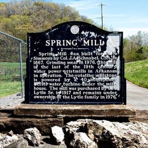 Weathered "Spring Mill" historical marker sign on stone platform