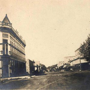 Multistory buildings and storefronts with covered entranced on dirt road