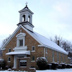 Brick building with covered porch and cupola in winter