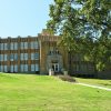 Multiple story brick hospital building with steps on hill