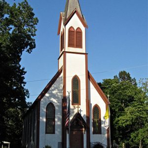 brown and white building with tall steeple tower with cross on top