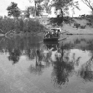 Ferry boat on river with house in the background