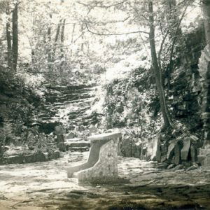 Stone grotto with steps and arched entrance dappled in sunshine