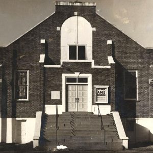 Brick church building with steps leading up to front doors