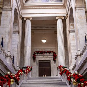 Staircase in marble hall leading to double doors with skylight above