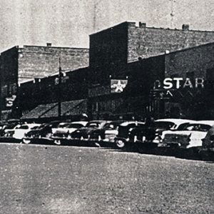 Street and brick storefronts with "Star" theater and parked cars