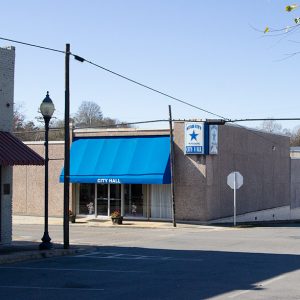 City block with building with blue banner "City Hall"