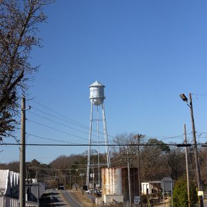 Water tower beside street with traffic