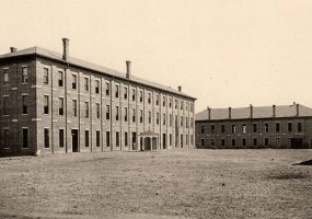 Multistory brick prison buildings with chimneys