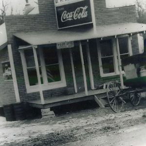 Single-story storefront with Coca-Cola sign and covered porch