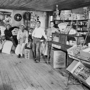 White men and women standing in store with boxes and glass display case