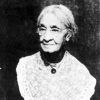 African-American woman with glasses in lace-collared dress