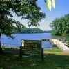 Lake with park sign trees and boat dock