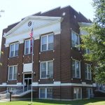 Multistory brick building and flagpole on grass