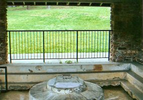 White circular cap over spring under brick and concrete pavilion