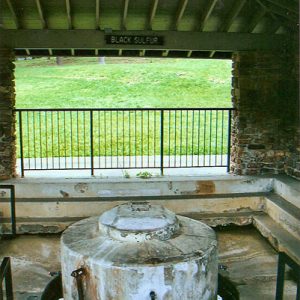 White circular cap over spring under brick and concrete pavilion