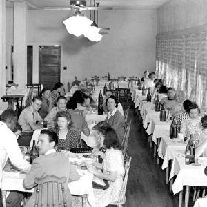 African-American man in uniform serving white men and women in dining hall