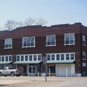 multistory brick building with truck on street parked in front