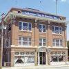 front and side view of three-story brick building with "Arkansas Flag & Banner, Inc." banner and skyscraper in background