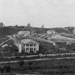 view of Multistory house and single-story buildings on hill