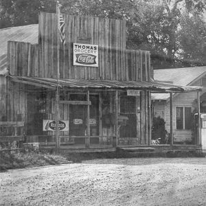 Wooden building "Thomas Grocery" and dirt road