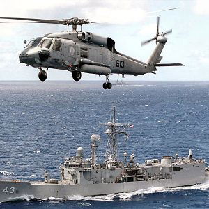 Helicopter flying over ship at sea