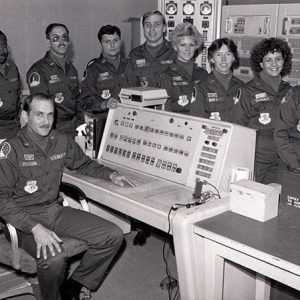 Group of men and women in U.S. Air Force uniforms in computer room