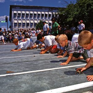 White children racing toads on city street