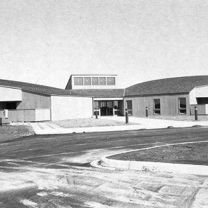 Building with rounded wings and skylight on circular driveway