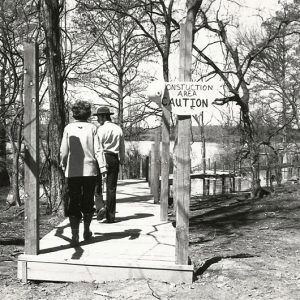 Park ranger leading white woman down walking path at park