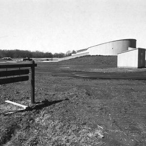 Looking towards rounded wall of building outbuilding and sign in foreground