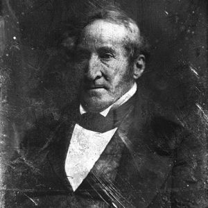 Portrait older white man thin hair long sideburns in suit and tie