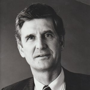 White man smiling in suit and tie