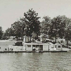 Boat dock with cars parked on hill behind it