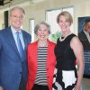 Old white man in suit and two white women smiling