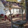 Side-view of single-story school house with wood siding and well in the foreground