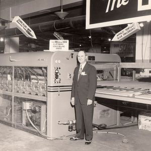 White man in suit and tie in factory with machinery