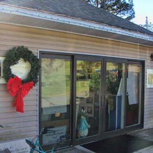 Close-up of single-story building with glass doors and Christmas wreath