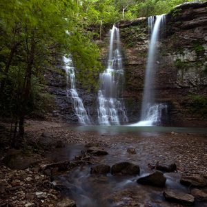 Natural waterfall with rock pool and trees