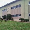 Multistory school building with logo panel and benches in front yard