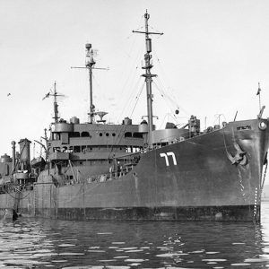 Close-up of naval ship at sea with number 77 on its bow and similar ship behind it in the background