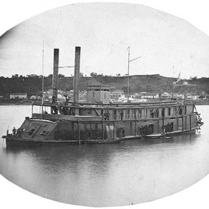 Naval steamboat on river with shore in the background in oval frame