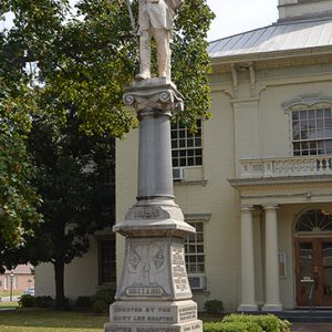 Statue of soldier on stone column with engraved pedestal on court house lawn