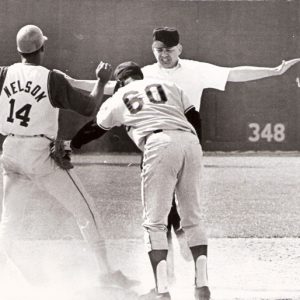 White umpire calling "safe" before two African-American baseball players