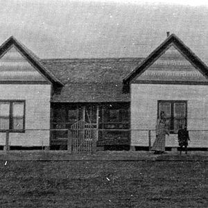 Woman and child standing before single story building