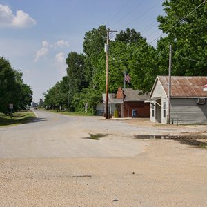 Single-story buildings and power lines on two-lane rural road