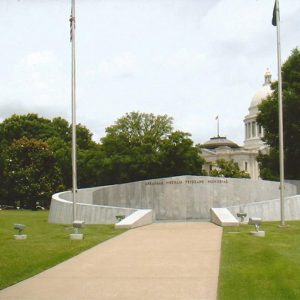 Entrance to memorial wall with curved concrete walls and flags